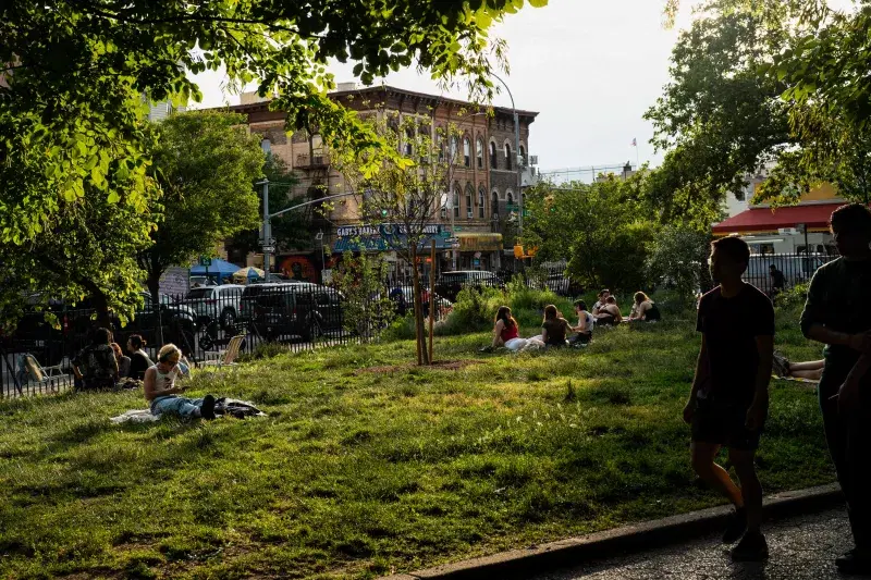 People sit on the grass and spend the day at Maria Hernandez Park in Brooklyn
