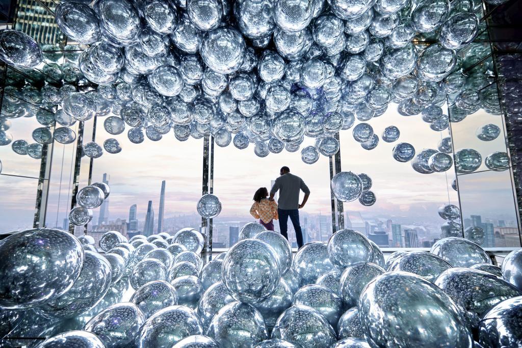Two people look at the city view from the Interior of Summit One Vanderbilt