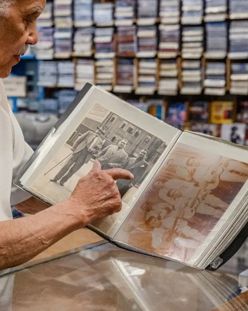Person pointing at old family photos at Casa Amadeo