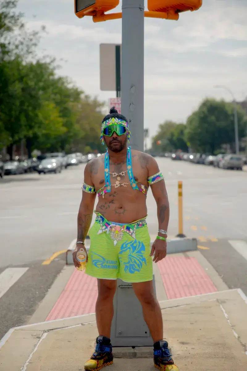 person in colorful clothing and googles standing in the middle of the street