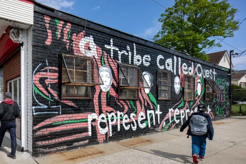 A Tribe Called Quest Mural on wall on the side of the street 