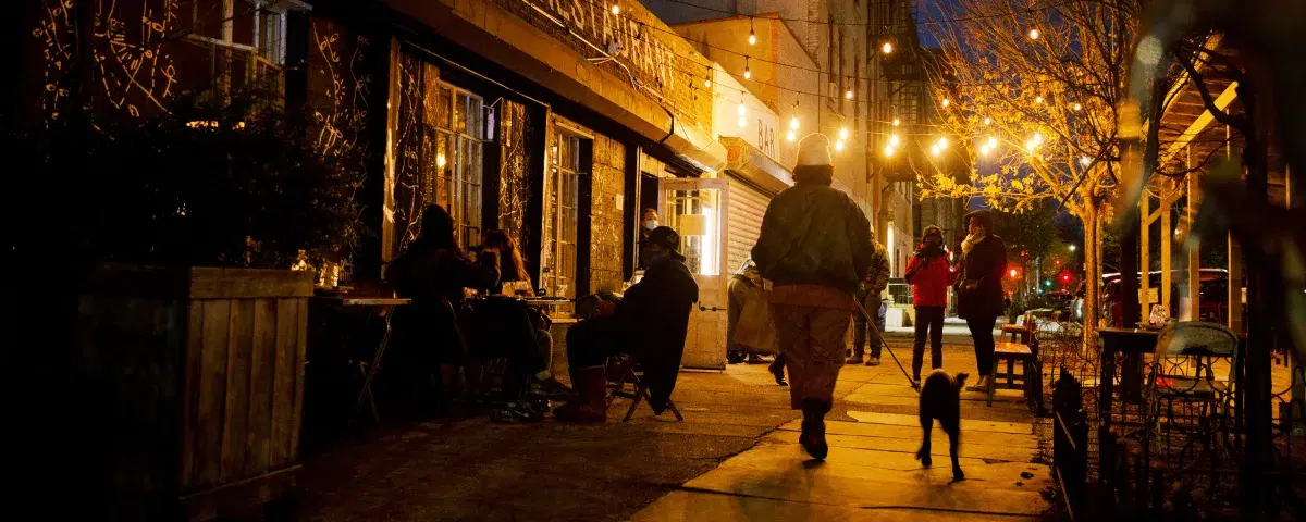 People walking down a street in Bed Stuy, Brooklyn at night