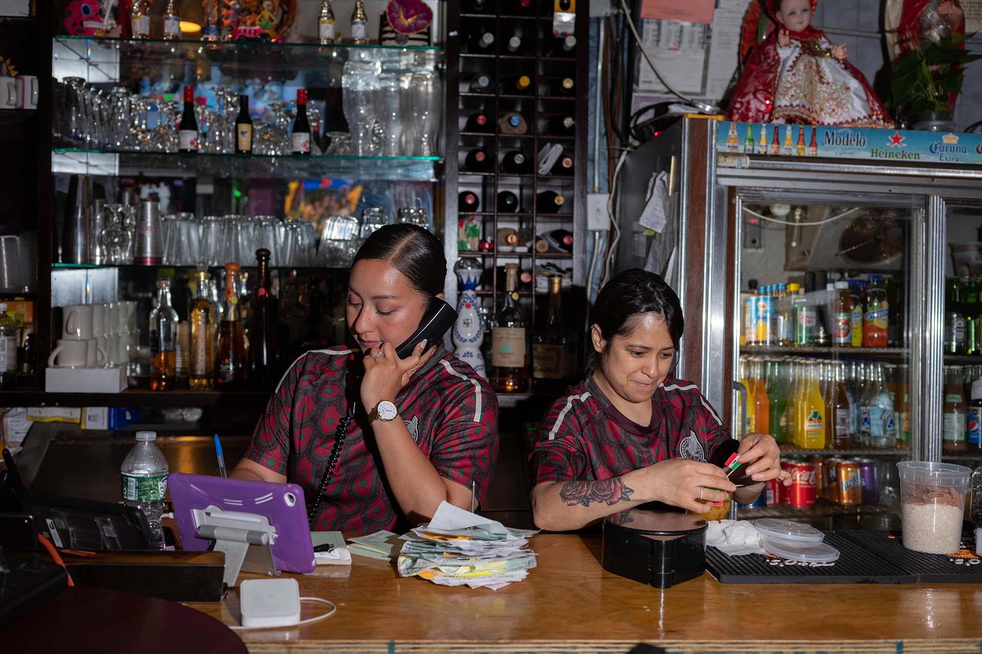 Two people take orders on the phone at Xochimilco.