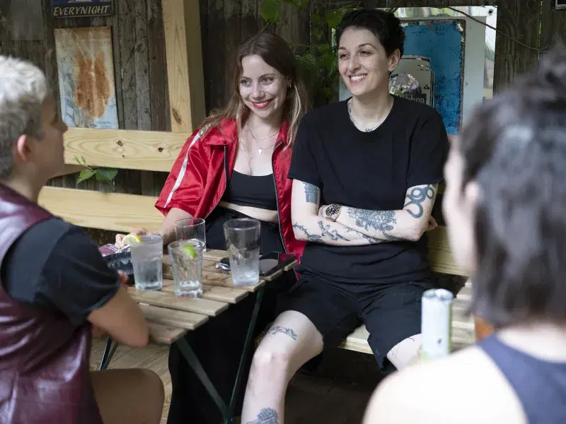 Sophia (left); Mollie (right), sitting, and talking to a couple more people at the bar