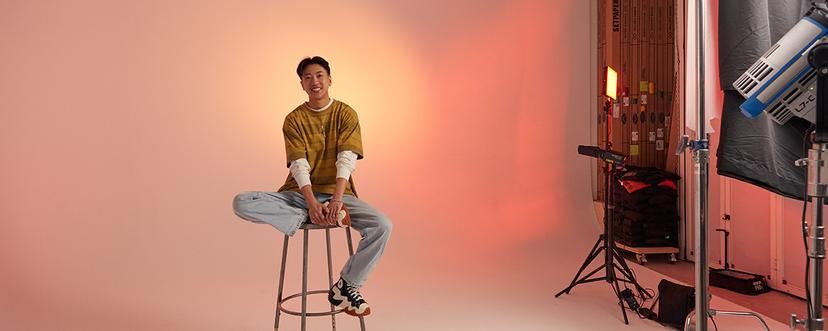 James Tom sitting on stool during photoshoot