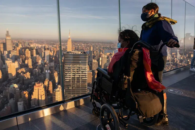 Two people look at the view from Edge NYC, an outdoor sky deck at Hudson Yards, in Manhattan