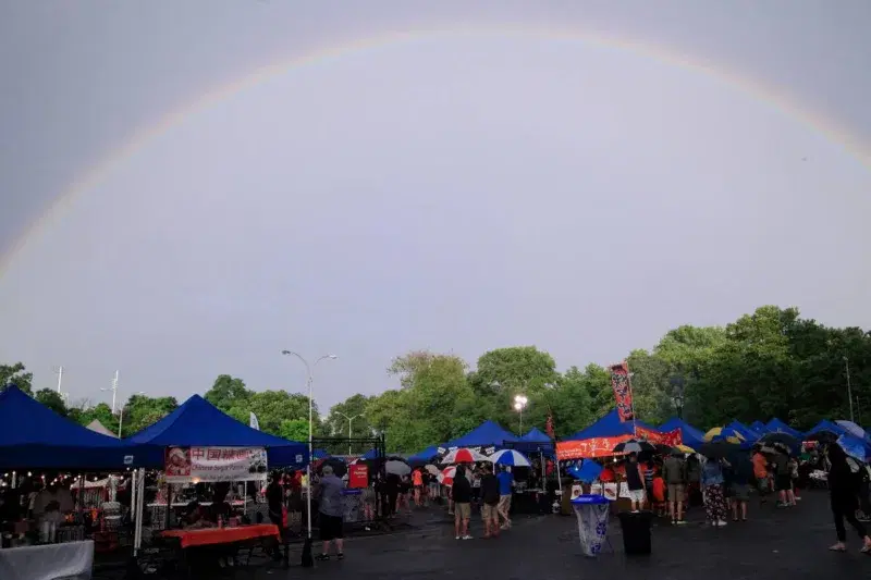 a rainbow in the sky over Queens Night Market in Flushing