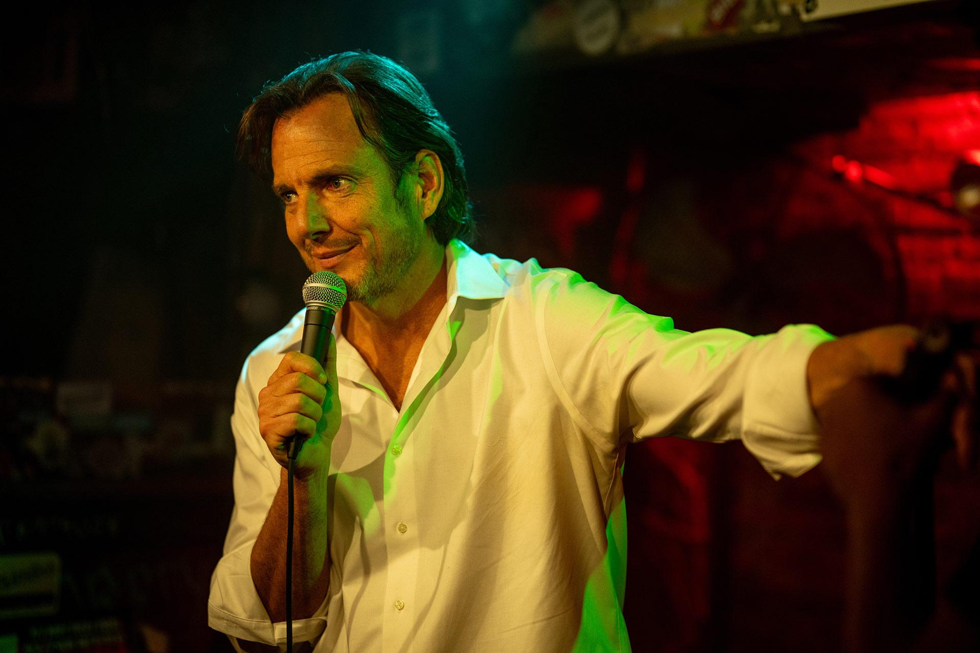 A man holding a microphone at Comedy Cellar