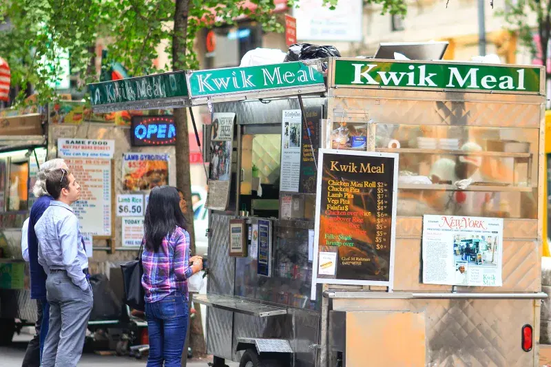 People ordering food at Kwik meal food cart 