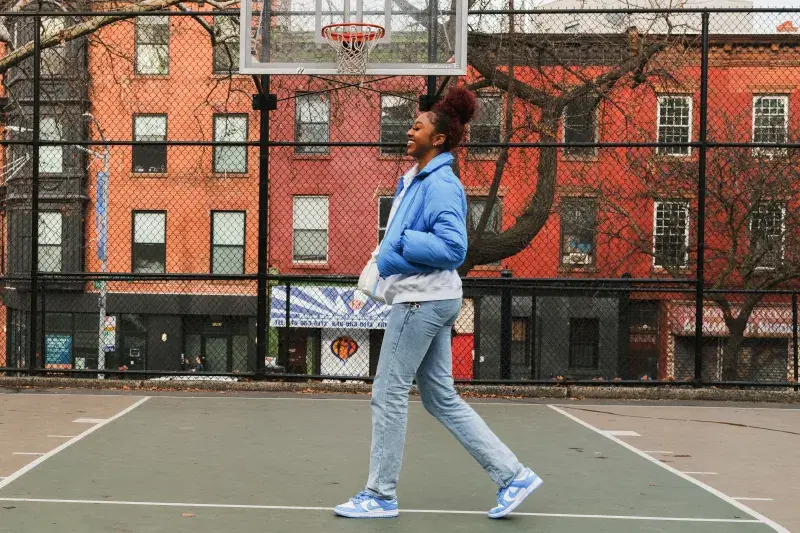 Portrait of DiDi Richards, walking on a basketball court in Brooklyn