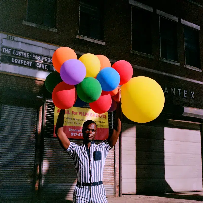 Person holding colorful balloons on the street