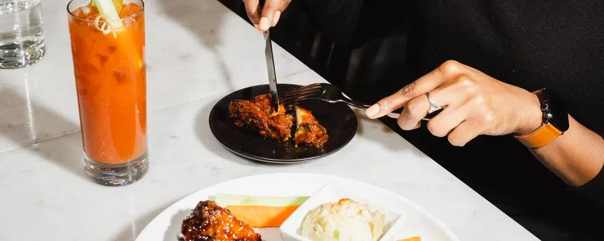 image of a person using utensils to cut their meal