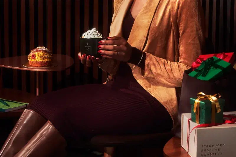 a person holds a signature drinks from the holiday menu 