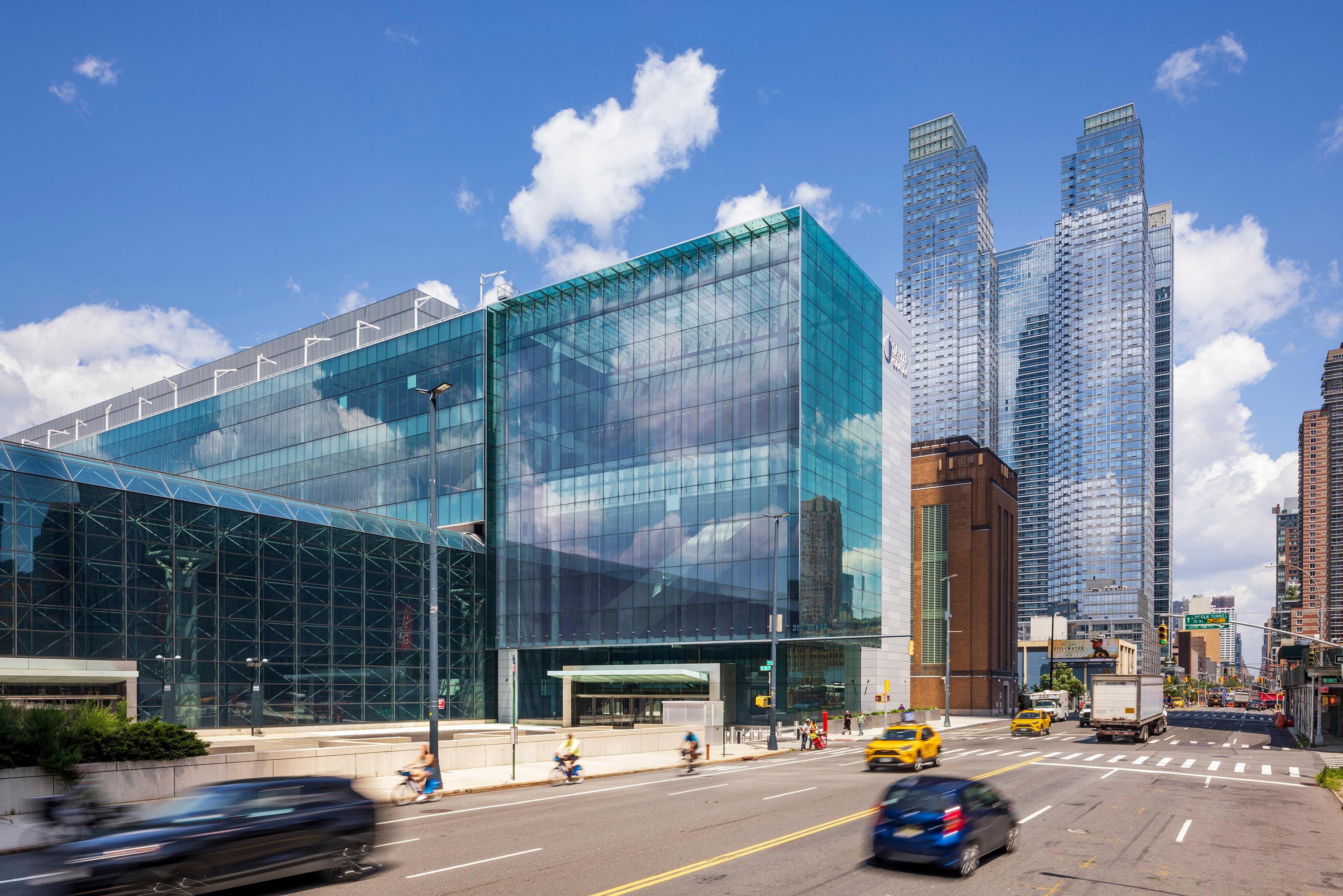 Yellow cabs and cars drive in fron of the Javits Center