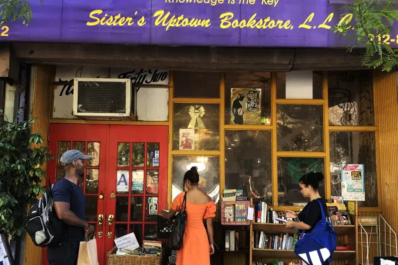 people looking at books, at Sister’s Uptown Bookstore, exterior, Manhattan