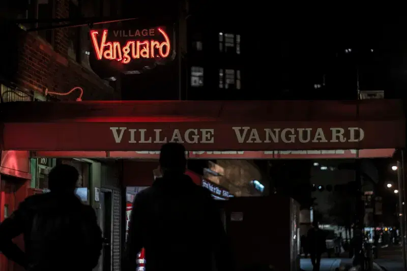 People walking outside Village Vanguard Jazz Bar at night.