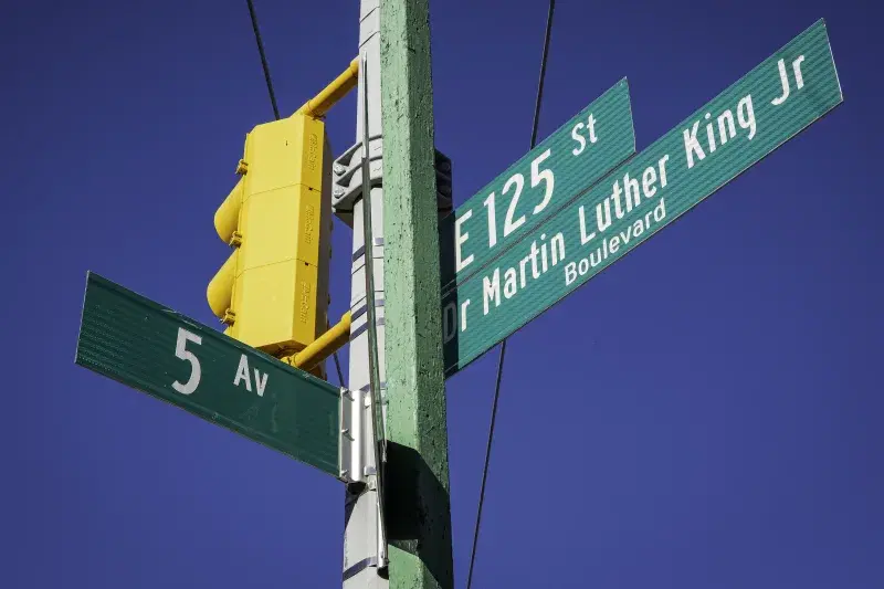 Street signs against blue sky in Harlem, Manhattan