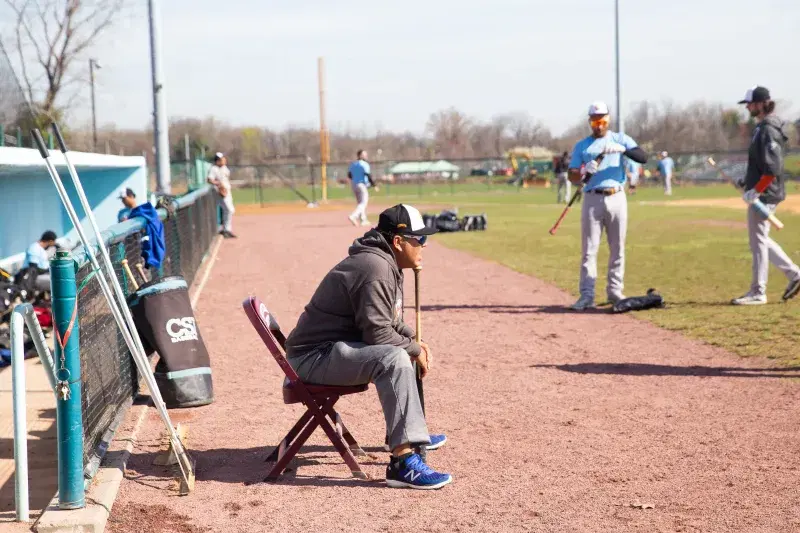 Edgardo Alfonzo, looking out to the baseball field, while sitting on a chair