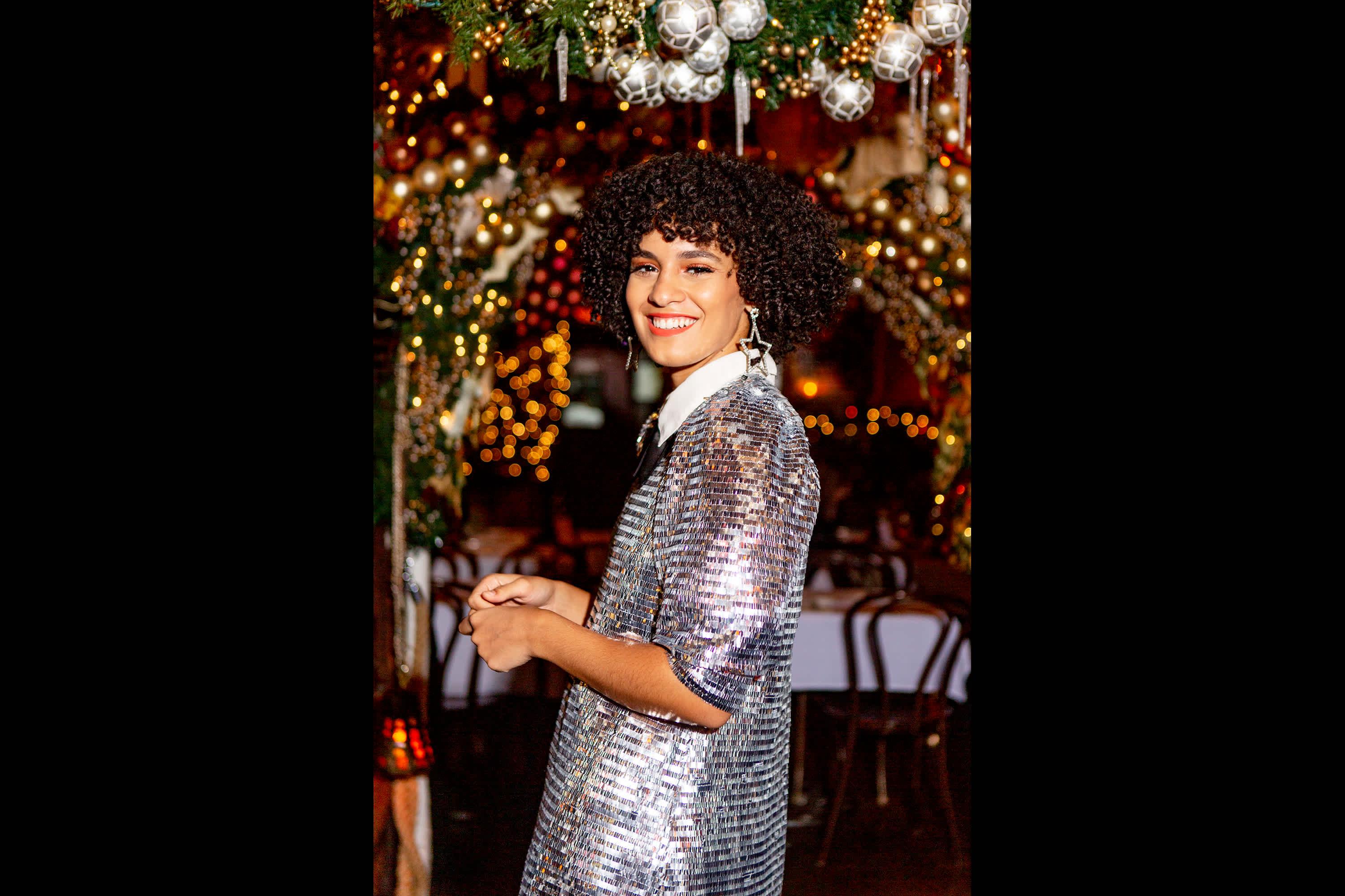 A person poses for the camera at Rolfs Gramercy in Manhattan, with Christmas ornaments in the background
