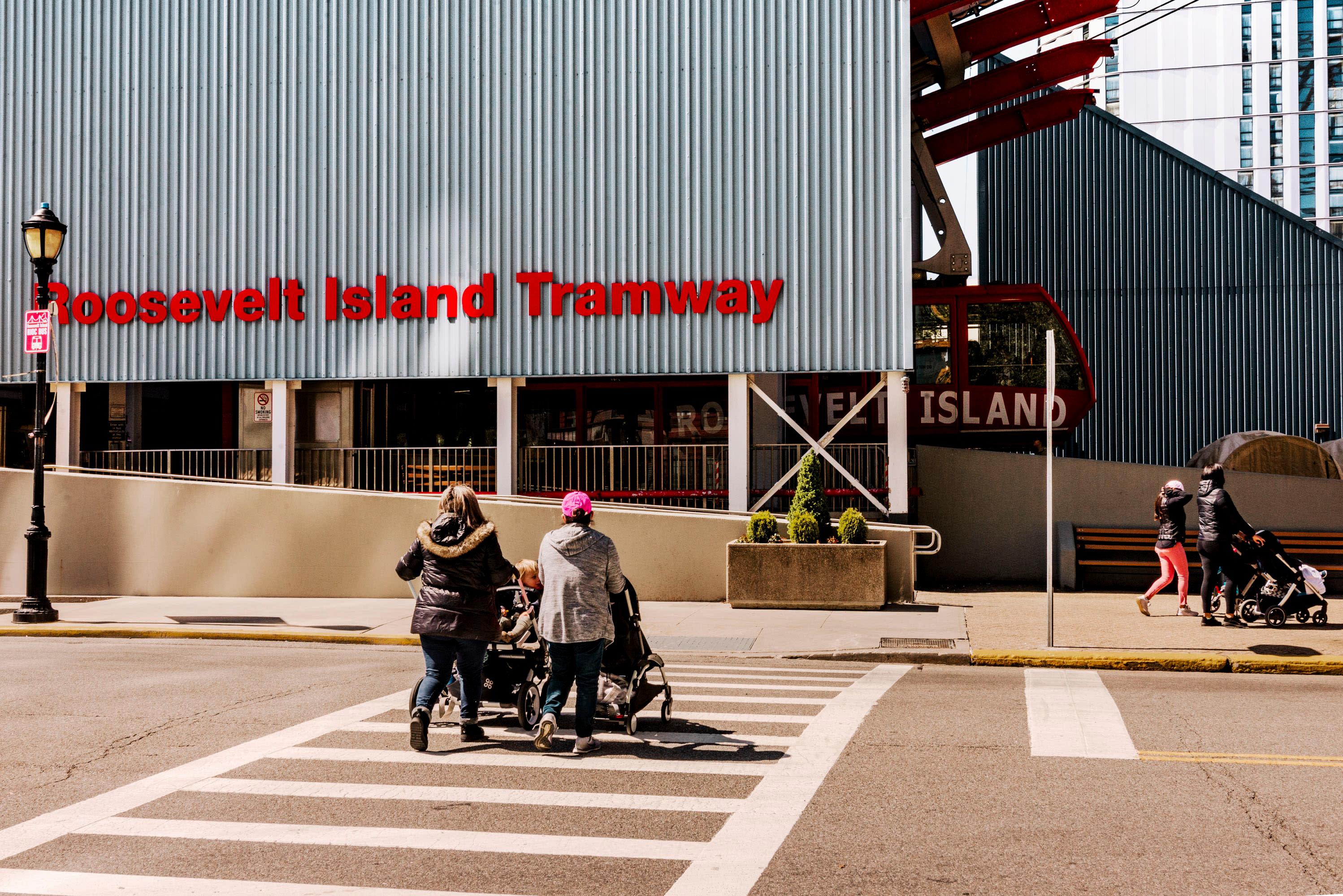 Two people walk toward Roosevelt Island Tramway
