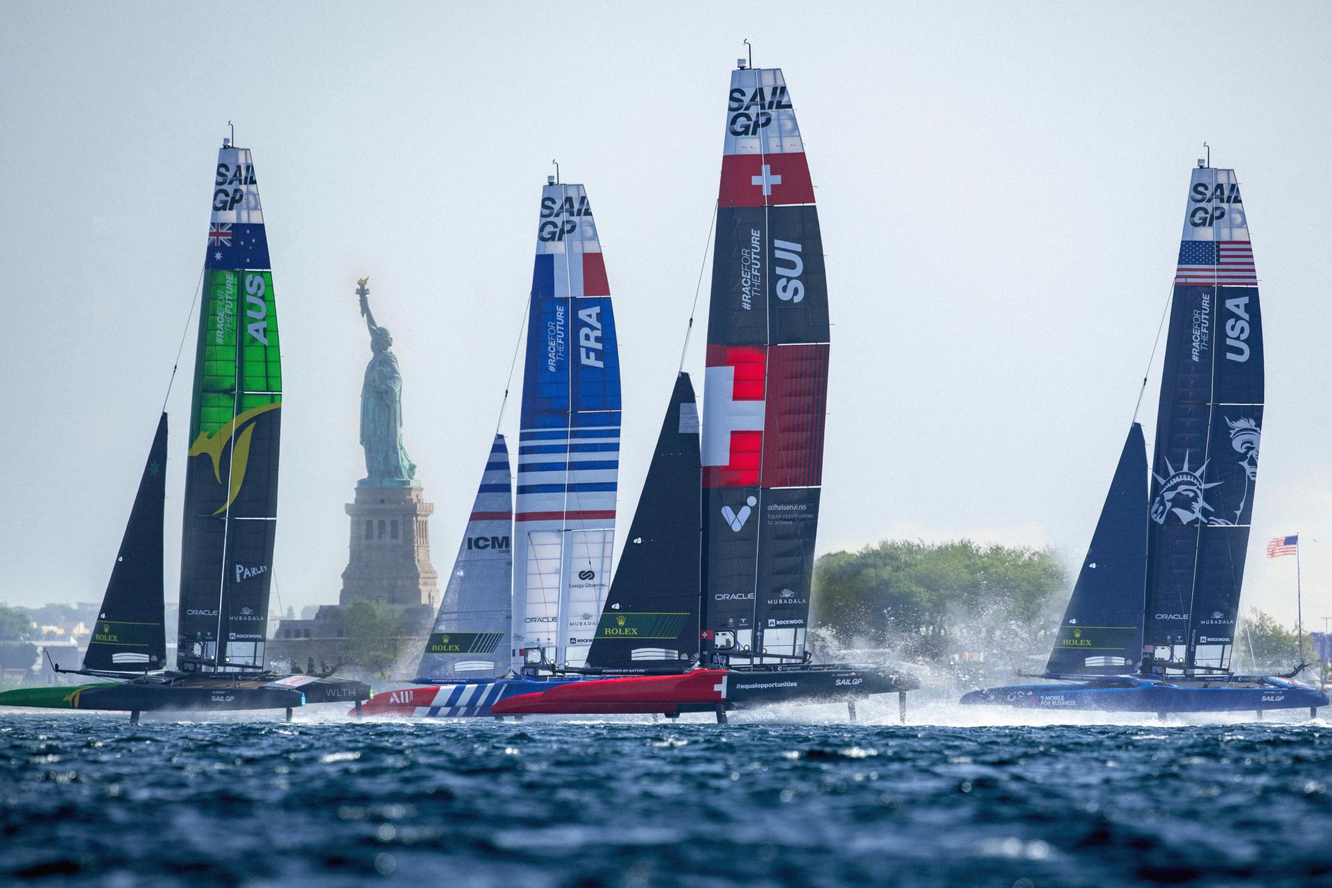 Sailboats competing in Sail GP near the statue of liberty